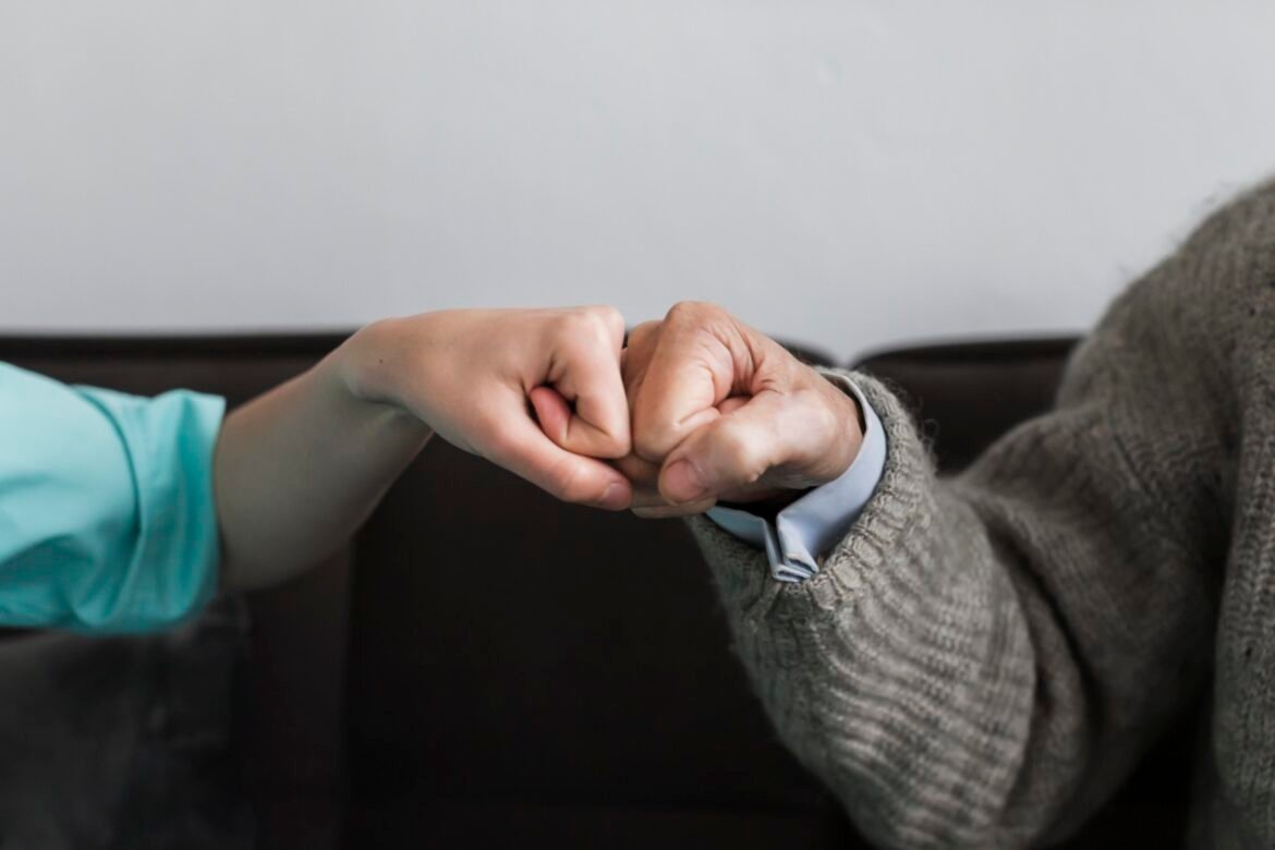nurse older man fist bumping